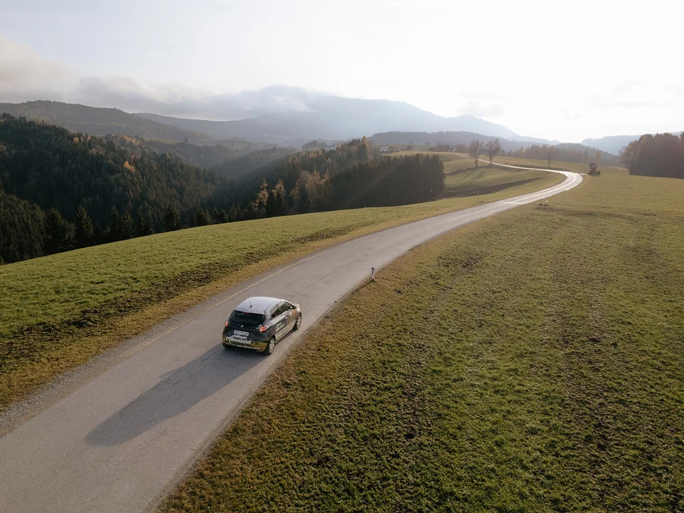 E-Auto mit Blick in den Naturpark Almenland.