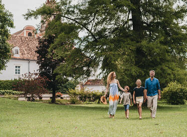 Eine Familie spaziert durch den Themengarten in der Oststeiermark.
