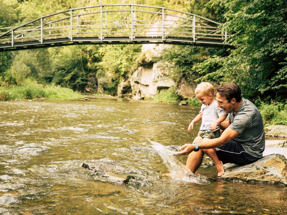 Vater mit Sohn pritschelt in der Raabklamm im Naturpark Almenland.