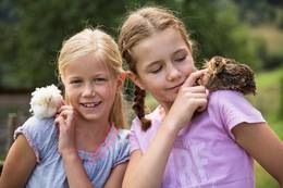 Kinder haben zwei Kücken auf ihren Schultern